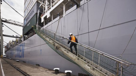 Ein Inspektor geht an Bord eines Containerschiffs