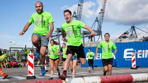 deelnemers Harbour Run springen over een van de obstakels