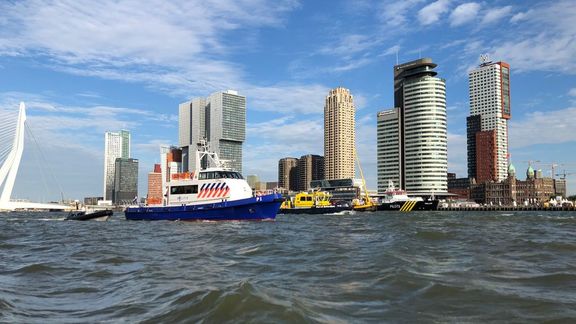 Skyline Rotterdam mit WPC im Hintergrund mit Hafenpolizei und Patrouillenboot auf dem Wasser