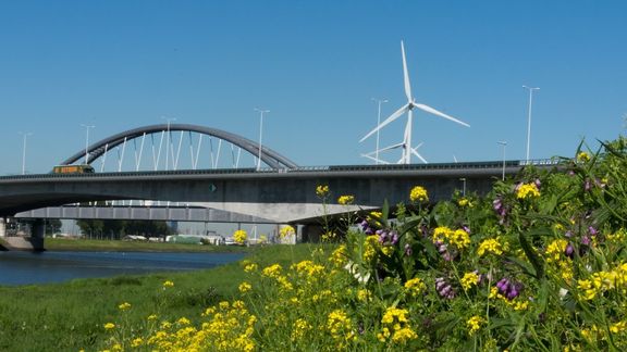 Viaduct, spoor, windmolen in het groen