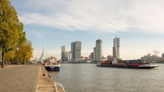Binnenvaartschip met de skyline van Rotterdam