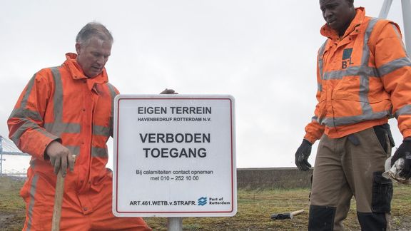 Mannen plaatsen een verbodsbord