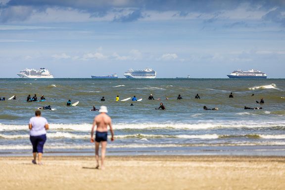 Schepen voor de kust met vakantiegangers op het strand