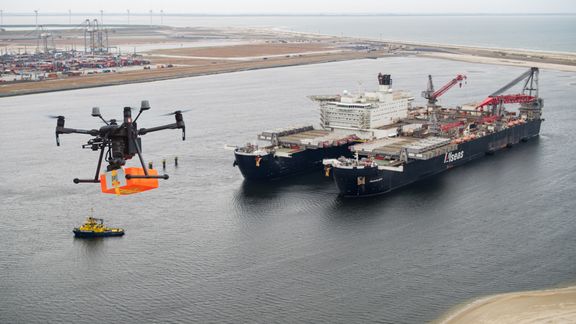 Een drone vliegt met een pakketje naar de Pioneering Spirit