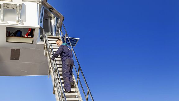 Man beklimt ladder binnenvaartschip