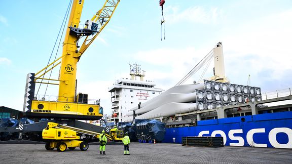 Men unload wind turbine blades