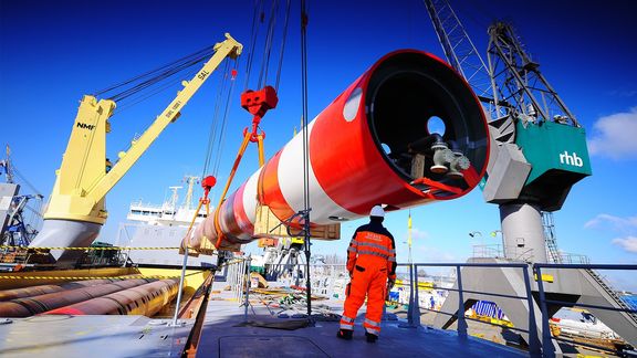 Pipe is loaded into ship with heavy lift