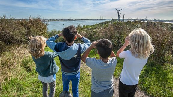 Kinderen kijken met een verrekijker vanaf landtong Rozenburg