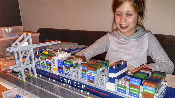 Jolijn met een containerschip en ­kranen gebouwd van lego