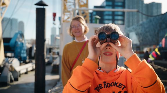 Jongen kijkt met verrekijker bij Maritiem Museum