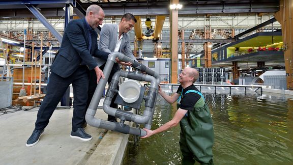 Onderzoeker en aquarist Sander van Lopik toont het drijvende kweeksysteem aan zijn directeur Erik Zevenbergen (links) en Richard van der Eijk (Havenbedrijf Rotterdam).