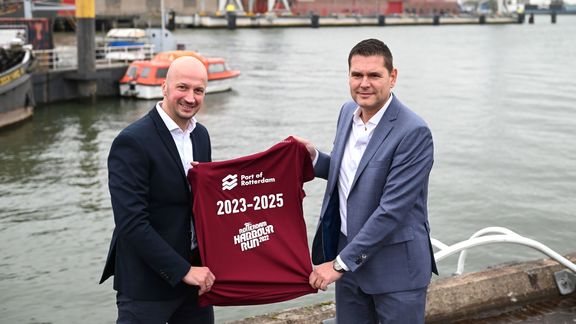 Martin den Ouden (links) en Richard van der Eijk tonen het nieuwe shirtje voor de Harbour Run aan de kade van de RDM Rotterdam