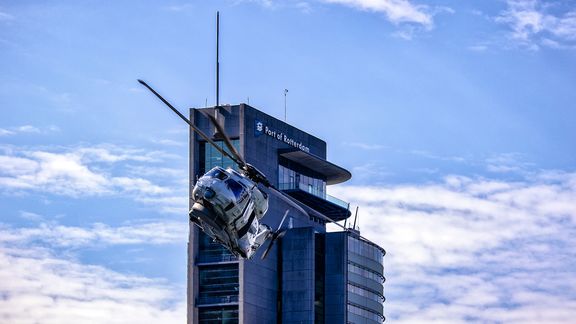 Helikopter met World Port Center op de achtergrond