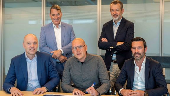 Onder toeziend oog van onder anderen Boudewijn Siemons, rechtsboven, ondertekent John Verberk – projectleider van Dura Vermeer – het contract met Havenbedrijf.