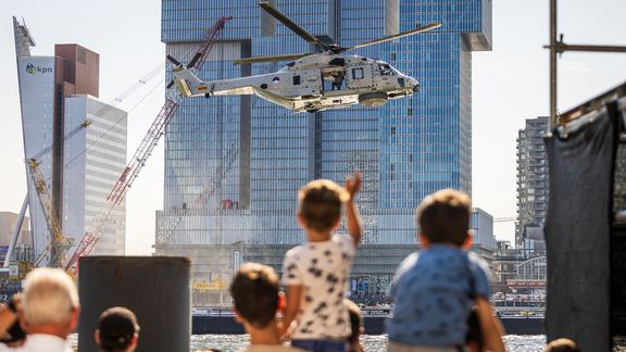 Jongen zwaait op schouders van zijn vader naar helikopter tijdens Wereldhavendagen 2022