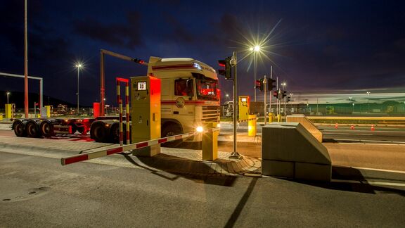 Vrachtwagen komt aan bij terminal en wacht voor de slagboom