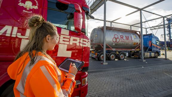 Een medewerker bekijkt de resultaten van de gescande vrachtwagens op een tablet