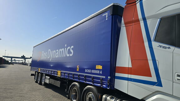 <strong>Blauwe Bos Dynamics-vrachtwagen op parkeerterrein</strong>.
