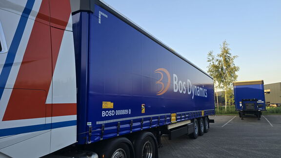 <strong>Blauwe Bos Dynamics-vrachtwagen op parkeerterrein</strong>.