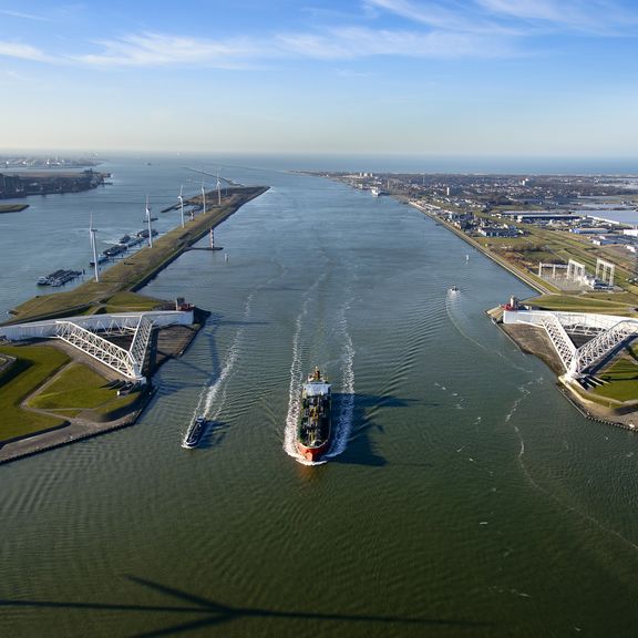 Een schip vaart langs de Maeslantkering