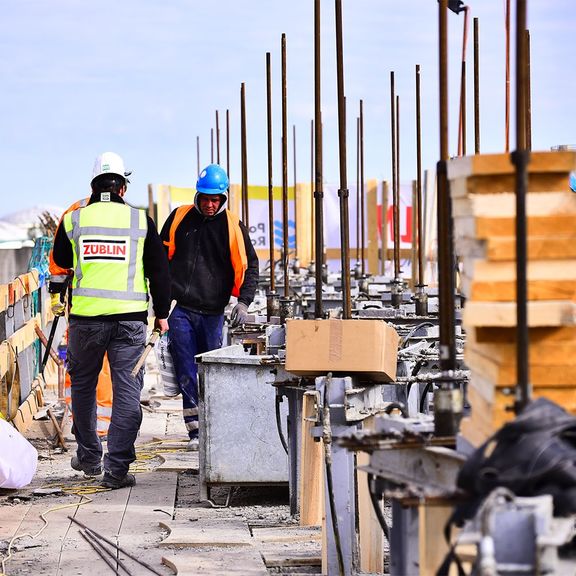 Zwei Männer arbeiten an der Errichtung von Windschutzvorrichtungen als Teil des Theemswegtracé