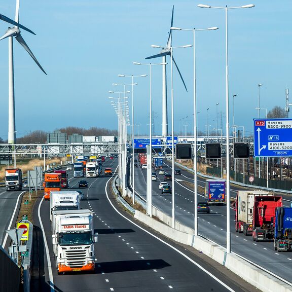 Vrachtverkeer op snelweg mat windmolens