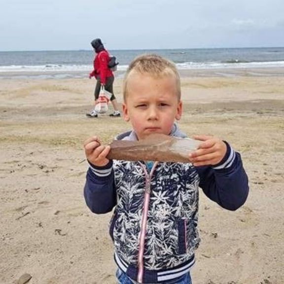 Dex uit Udenhout met stuk van mammoetbot op Maasvlaktestrand