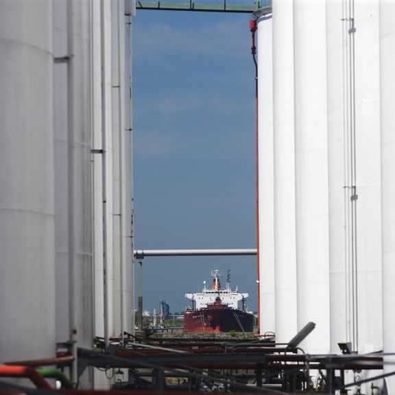 Oil tank storage with a ship in the backgroundOlie opslag met een schip op de achtergrond