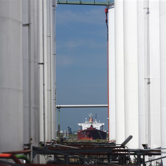 Öllagerung mit einem Schiff im Hintergrund