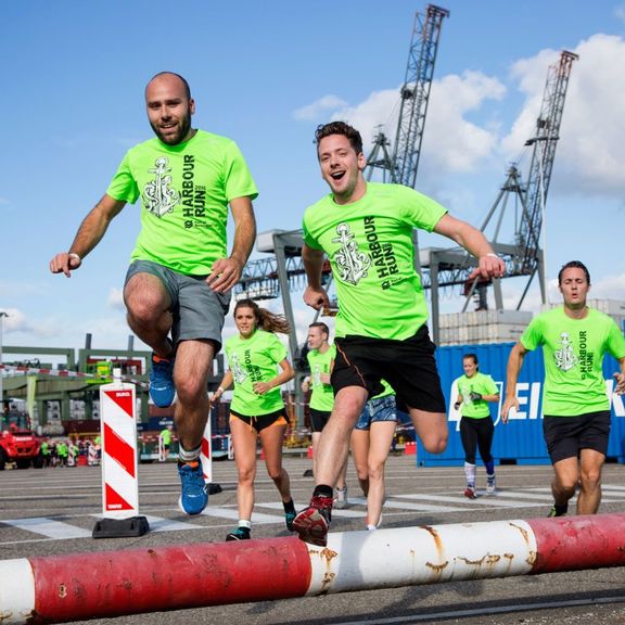 deelnemers Harbour Run springen over een van de obstakels