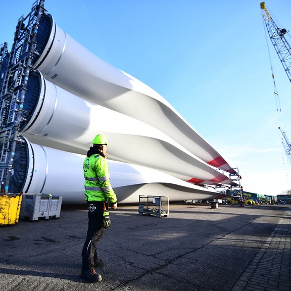 Hafenarbeiter an Rotorblättern von Offshore-Windkraftanlagen