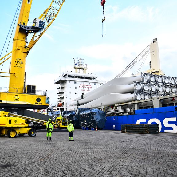 Men unload wind turbine blades