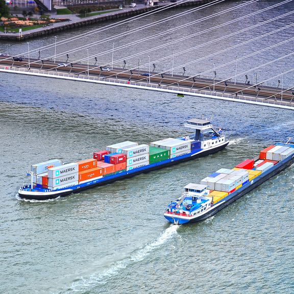 Containerships pass eachother under the Erasmus Bridge