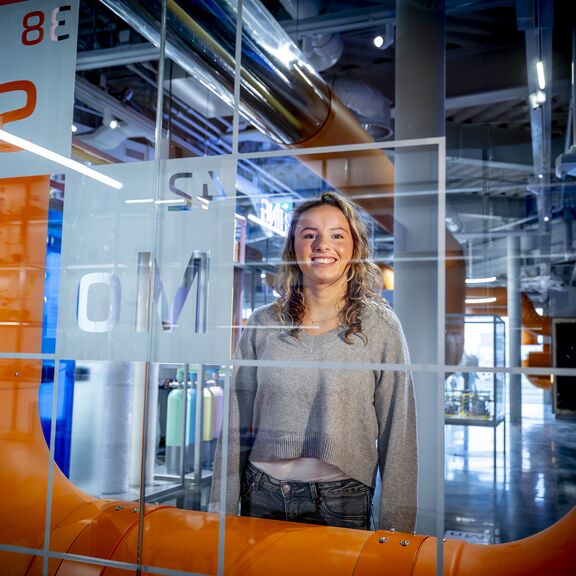 Student poseert bij een display in Portlantis