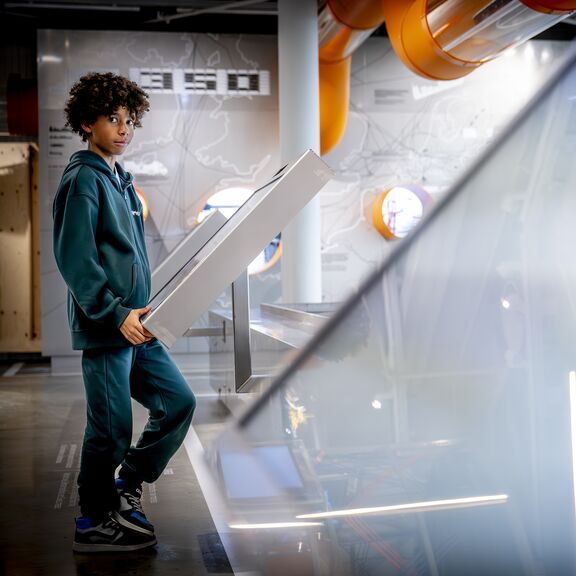 Jongen kijkt bij de display van de terminals in Portlantis