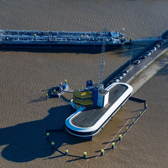 “Aerial photo of a cargo ship next to an industrial platform in the harbor.”