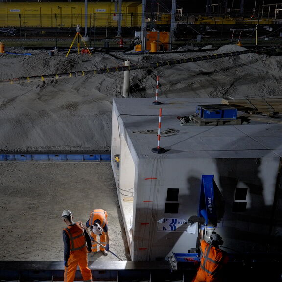 A skip is being placed on the Maasvlakte during the night